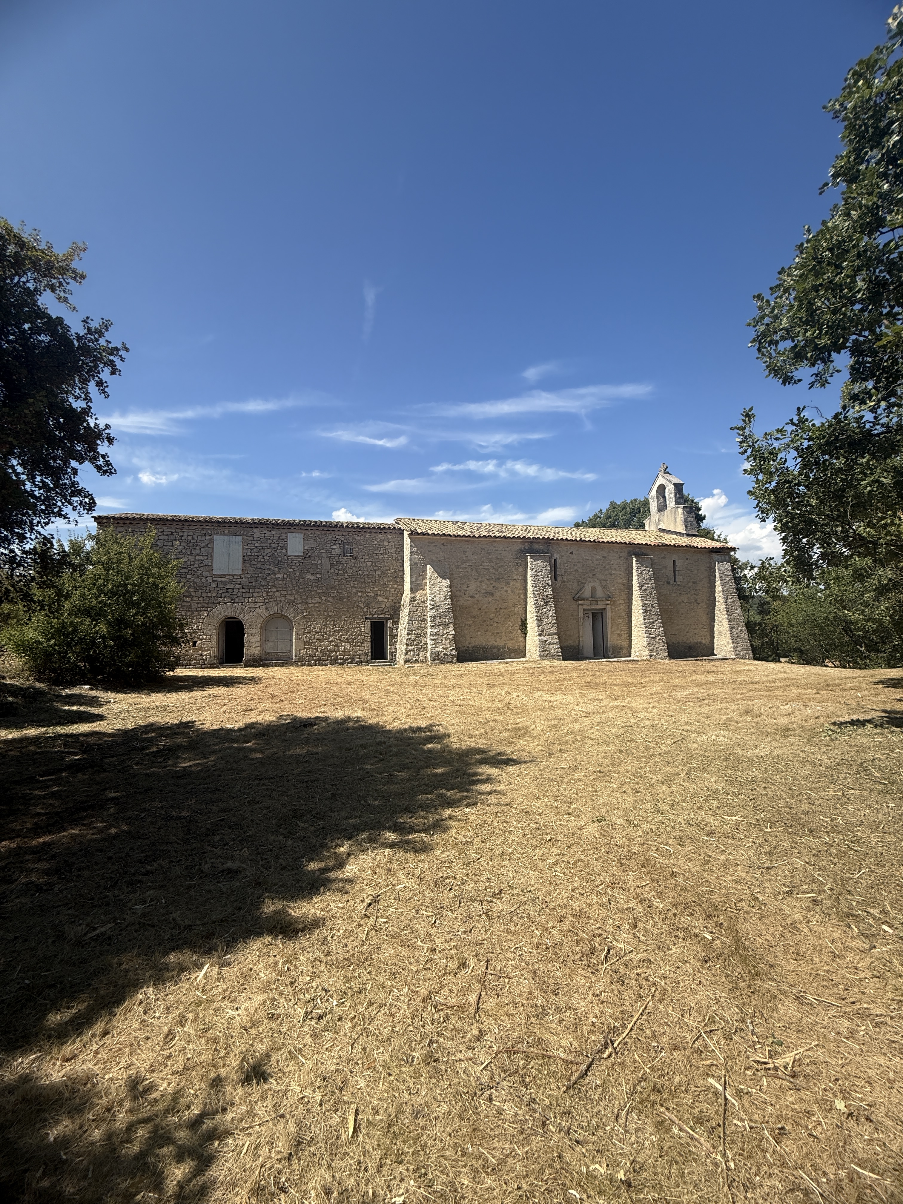 Façade en pierre du prieuré à l'heure dorée, Villemus